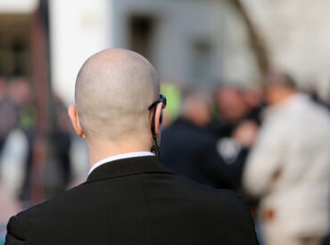 security guard with dark glasses and a radio headset to control people